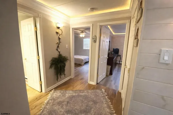 a view of a hallway with wooden floor and a living room
