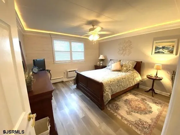 a bedroom with a bed chair and wooden floor