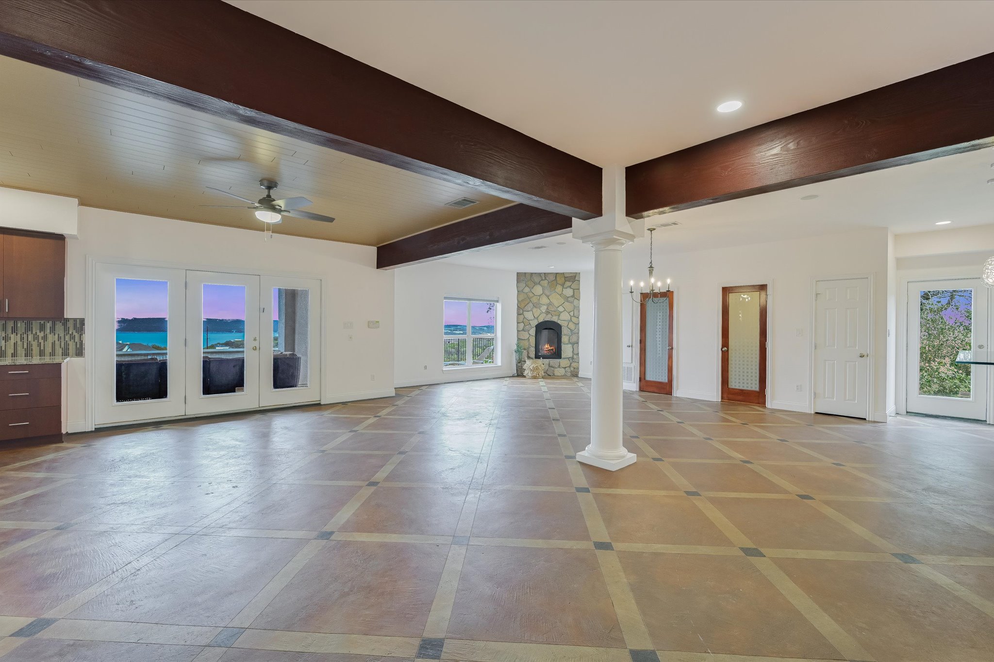 4319 Rum Runner Road Austin, TX 78734 - Photo 27 of 40 Unfurnished living room featuring beam ceiling, french doors, recessed lighting, ceiling fan, and decorative columns