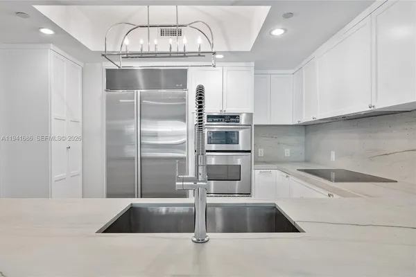 a kitchen with a refrigerator sink and cabinets
