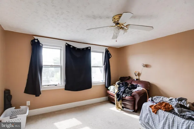 a living room with furniture and a ceiling fan