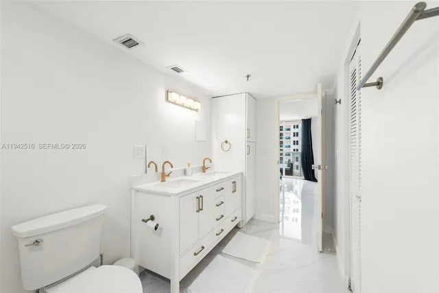 a bathroom with a sink toilet vanity and shower