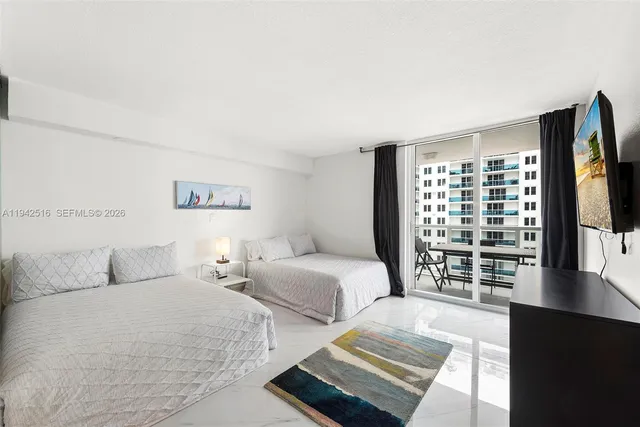 a bedroom with two beds and a large window