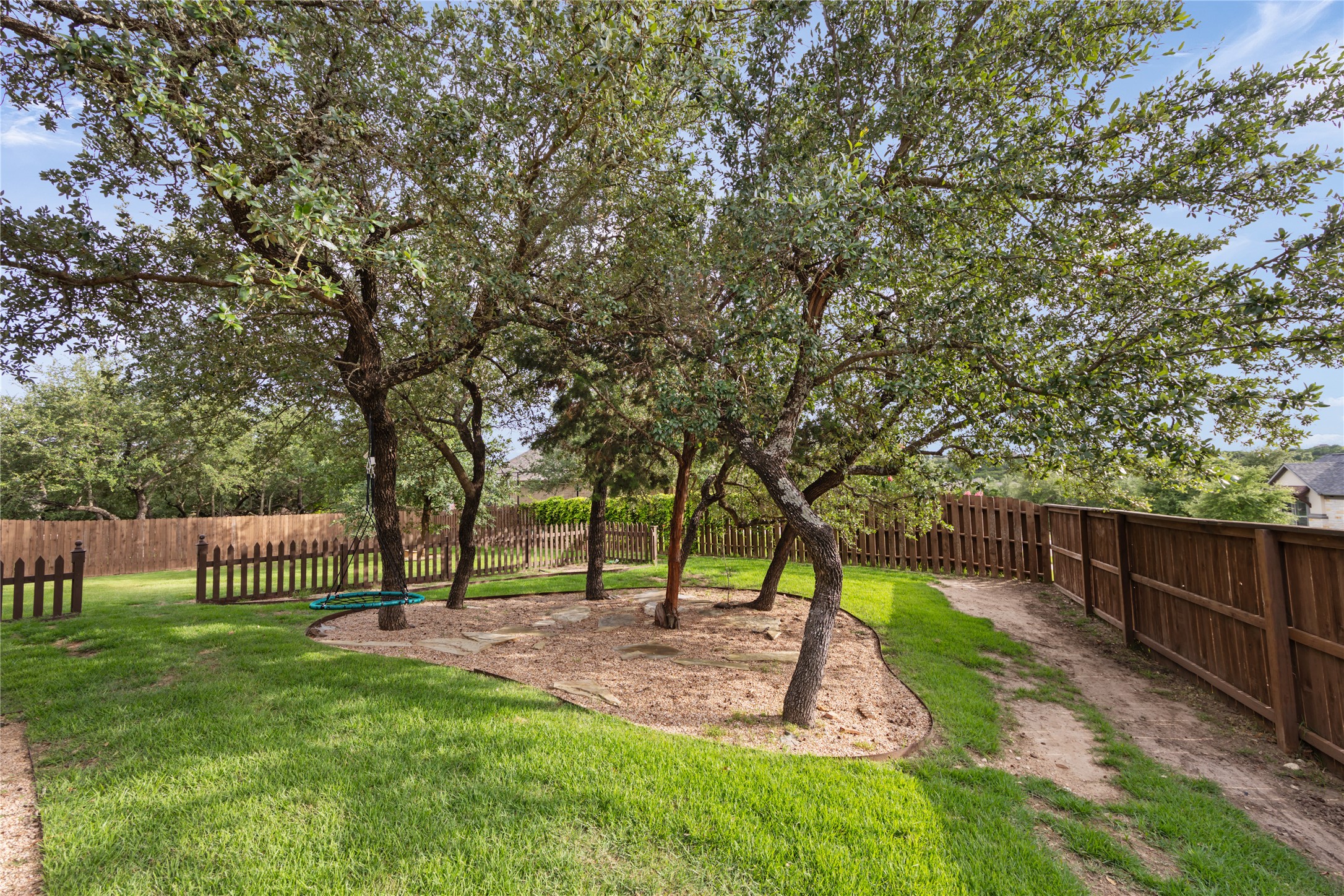 415 Bitterroot Lane Austin, TX 78737 - Photo 24 of 25 Mature trees and lush lawns define this generously proportioned, private backyard.