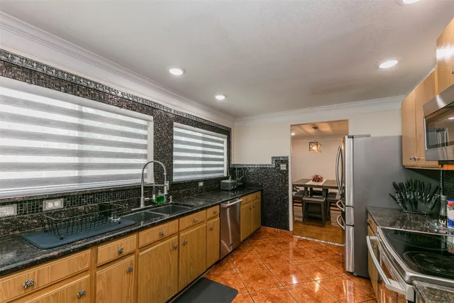 a kitchen with stainless steel appliances granite countertop a sink stove and refrigerator