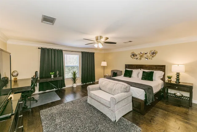 a spacious bedroom with a bed a couch and large windows