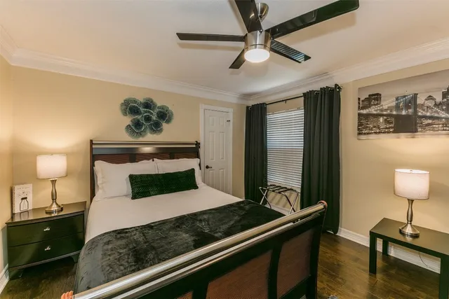 a bedroom with a bed a couch and a flat screen tv