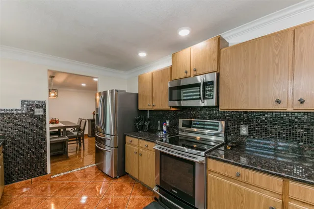 a kitchen with stainless steel appliances granite countertop a stove refrigerator sink and microwave