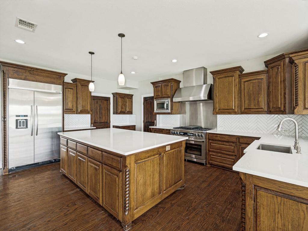 5975 Diamond Spur Frisco, TX 75036 - Photo 4 of 40 a kitchen with stainless steel appliances granite countertop a sink stove and refrigerator