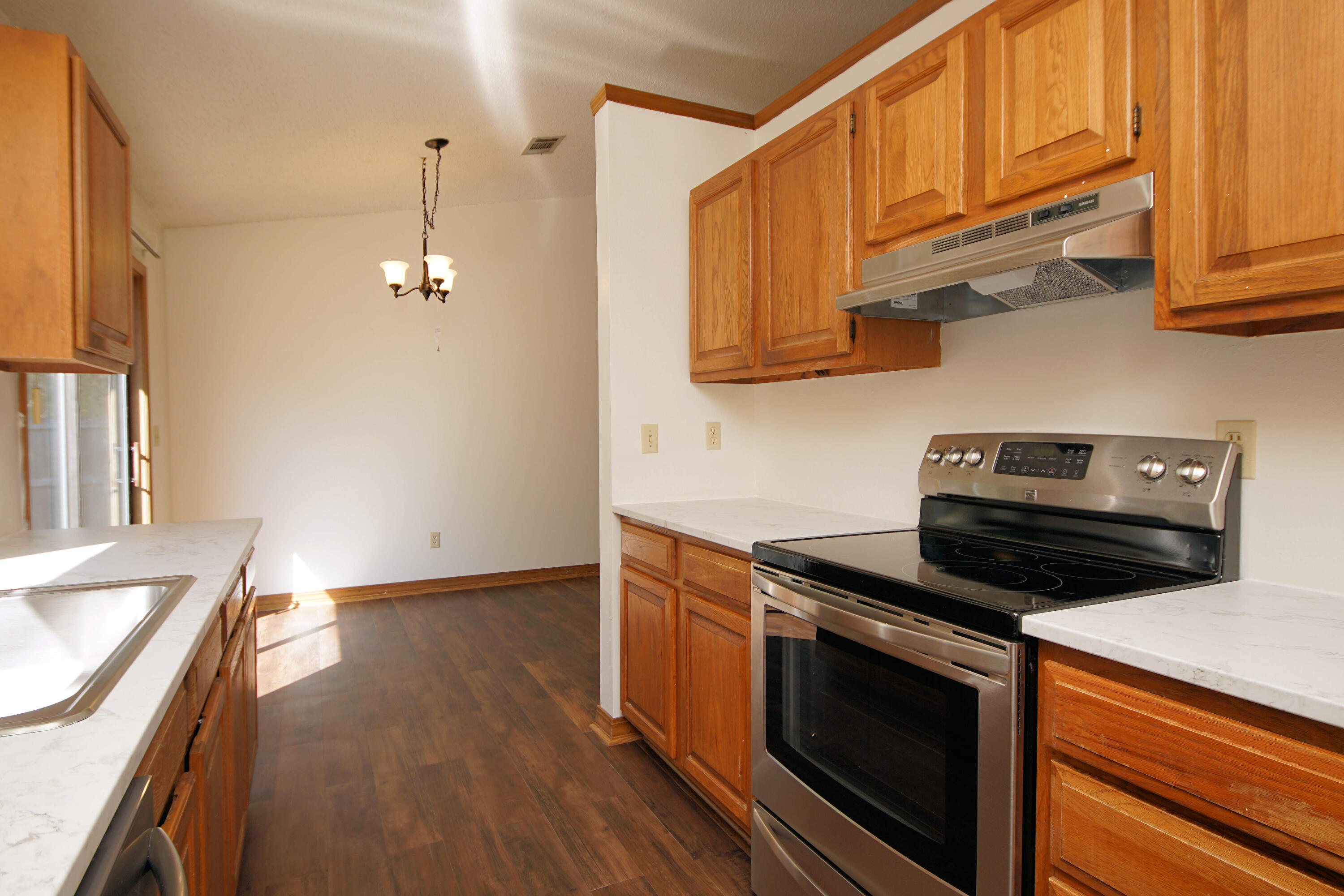 912 Nutmeg Avenue Niceville, FL 32578 - Photo 11 of 30 a kitchen with stainless steel appliances granite countertop a sink a stove and a wooden floors