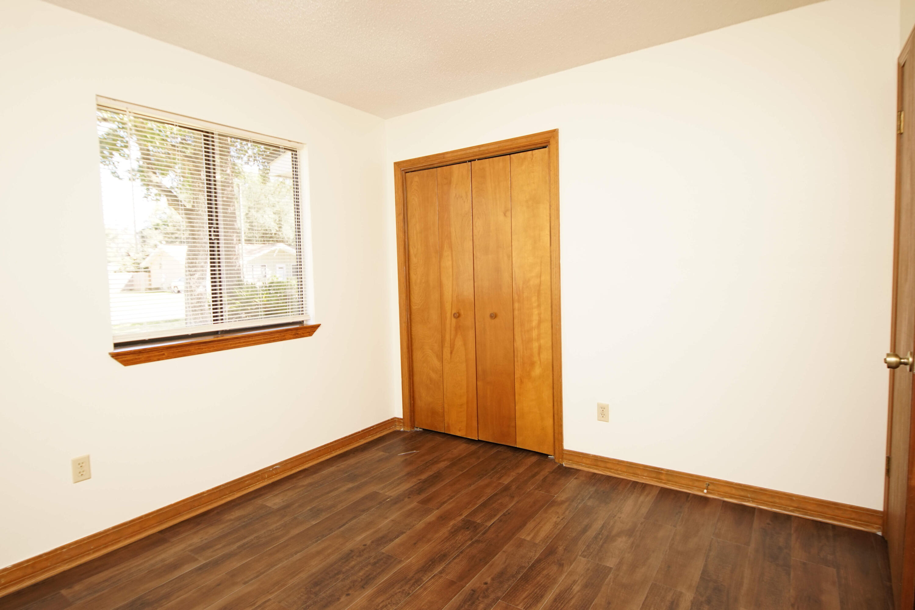 912 Nutmeg Avenue Niceville, FL 32578 - Photo 19 of 30 a view of an empty room with wooden floor and a window