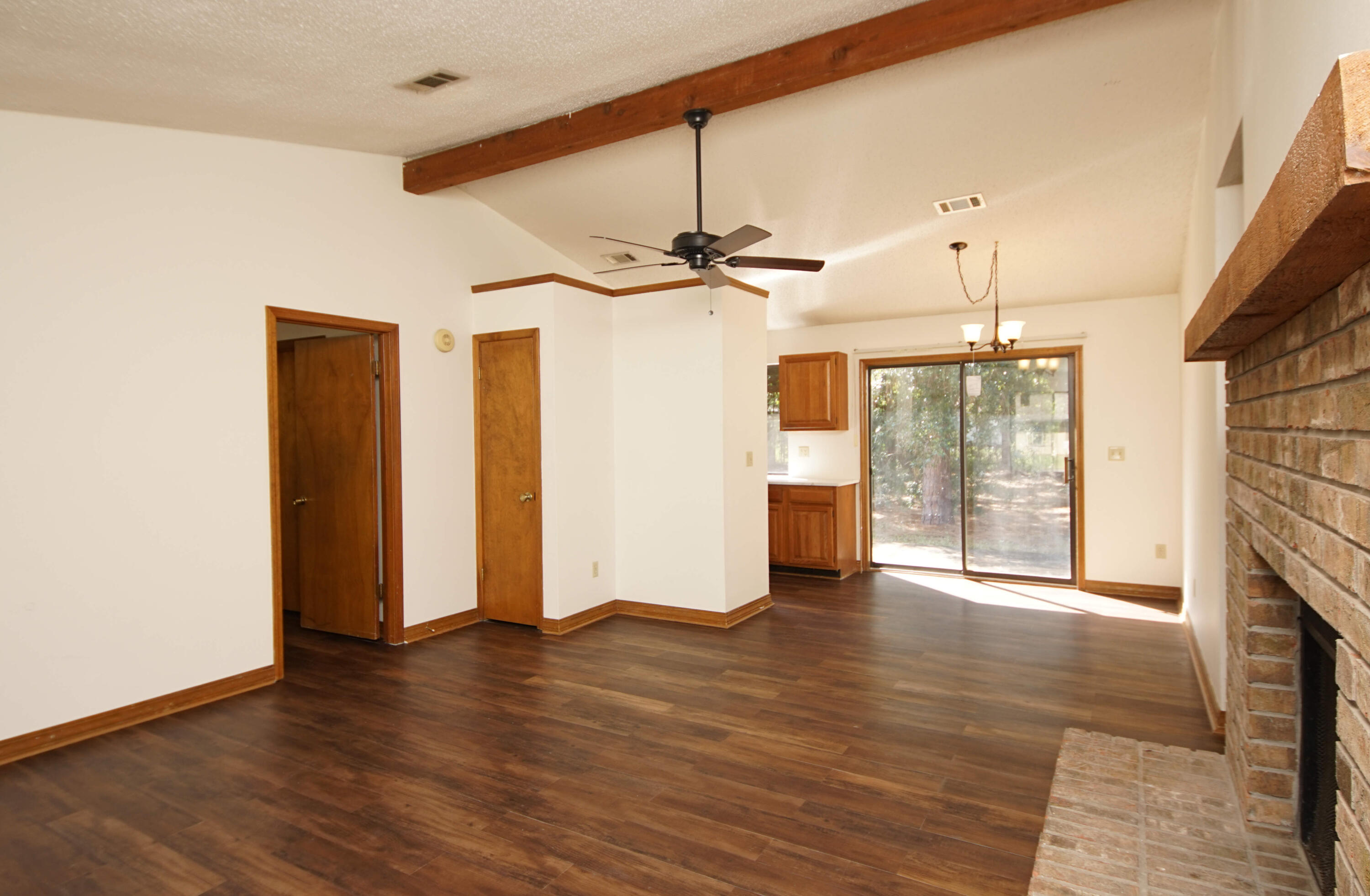 912 Nutmeg Avenue Niceville, FL 32578 - Photo 6 of 30 a view of a livingroom with wooden floor a ceiling fan and windows