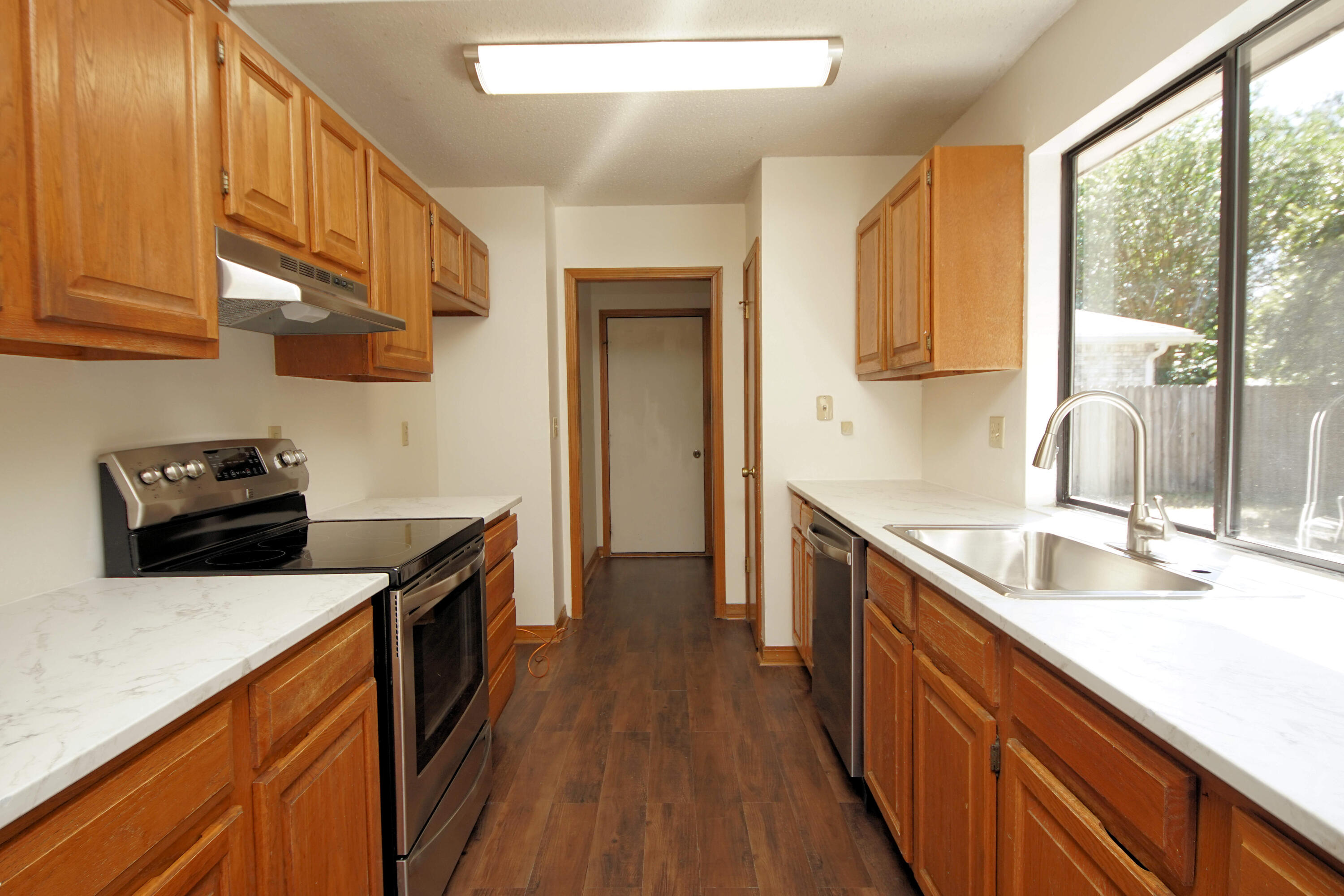 912 Nutmeg Avenue Niceville, FL 32578 - Photo 10 of 30 a kitchen with stainless steel appliances granite countertop a sink stove and refrigerator