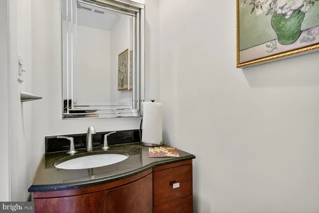 a bathroom with a granite countertop sink and a mirror