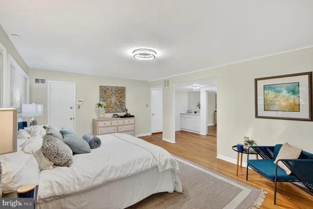 a large bedroom with a bed and wooden floor