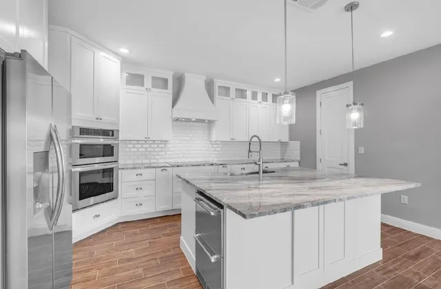 a kitchen with stainless steel appliances granite countertop a sink stove and refrigerator