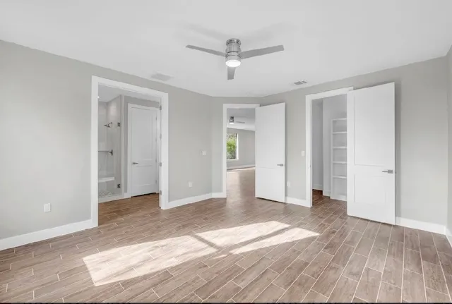 a view of a livingroom with wooden floor and a ceiling fan