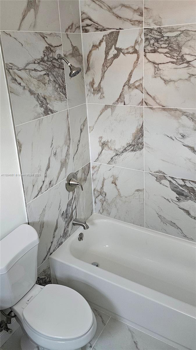 8372 Southwest 23rd Court Miramar, FL 33025 - Photo 13 of 22 a white toilet and tub sitting next to a bathroom sink