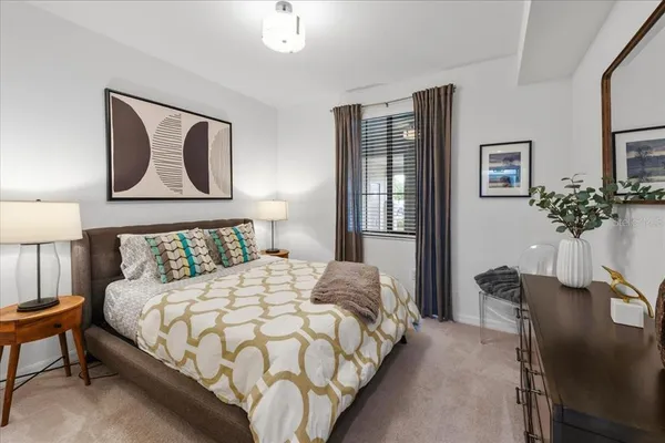 a bedroom with a bed and painting on the wall