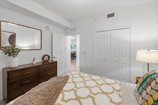 a bedroom with a bed and a lamp on dresser