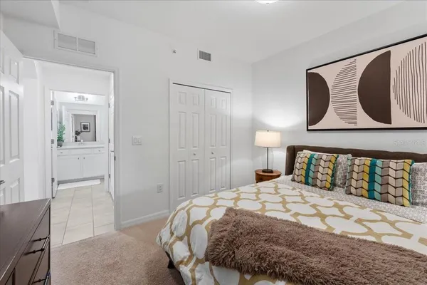 a bedroom with a large bed and a painting on the wall