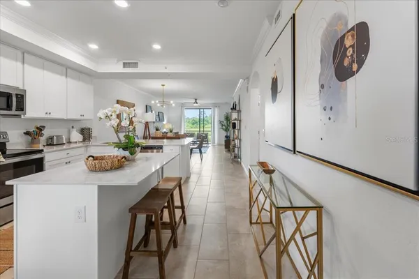 a kitchen with stainless steel appliances a table chairs and a refrigerator