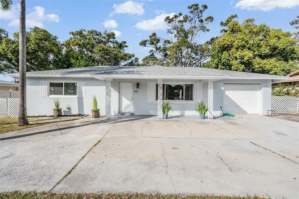 a front view of a house with a garden and a garage