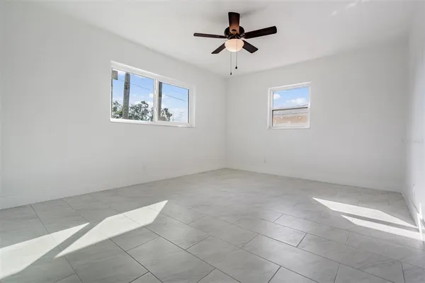 an empty room with a ceiling fan and carpet