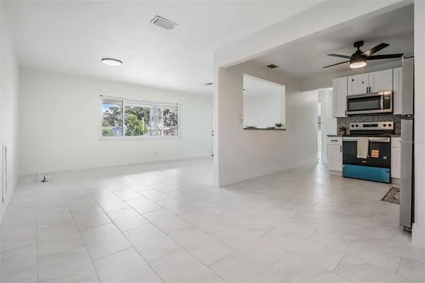a kitchen with stainless steel appliances granite countertop a refrigerator a stove a sink and white cabinets