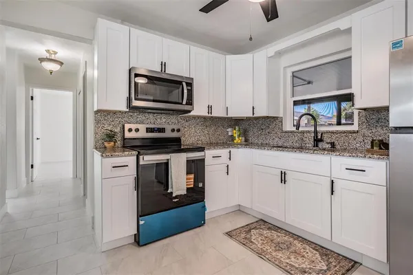 a kitchen with white cabinets and stainless steel appliances