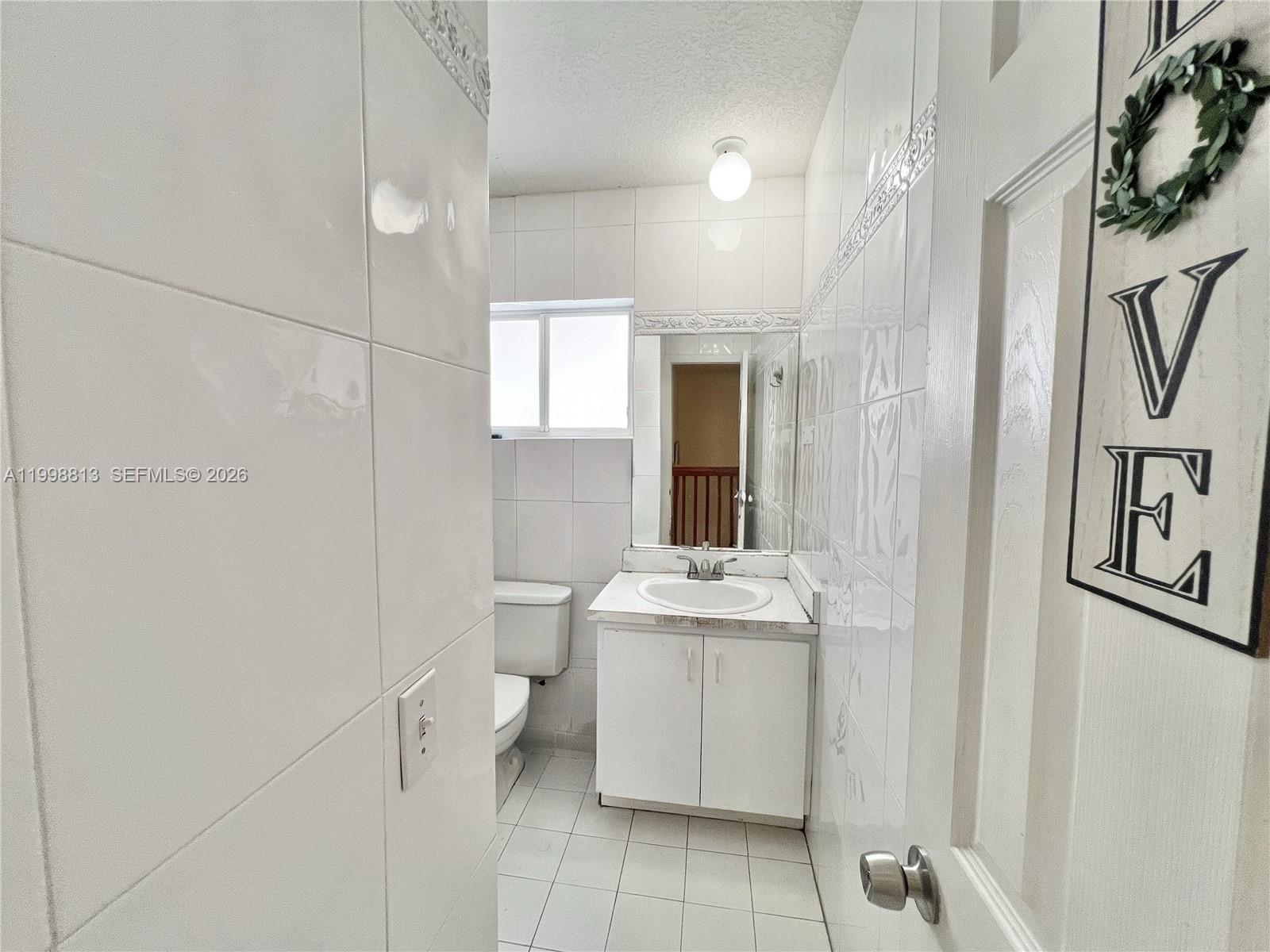 10140 Southwest 26th Terrace Miami, FL 33165 - Photo 13 of 70 a bathroom with a sink a toilet and mirror