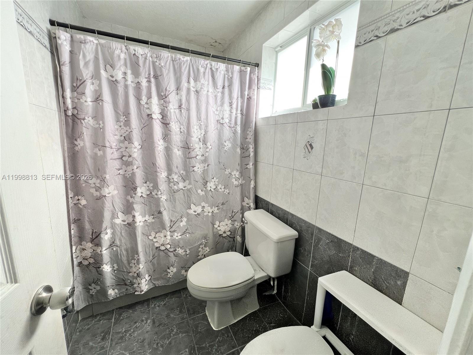 10140 Southwest 26th Terrace Miami, FL 33165 - Photo 29 of 70 a white toilet sitting next to a shower curtain