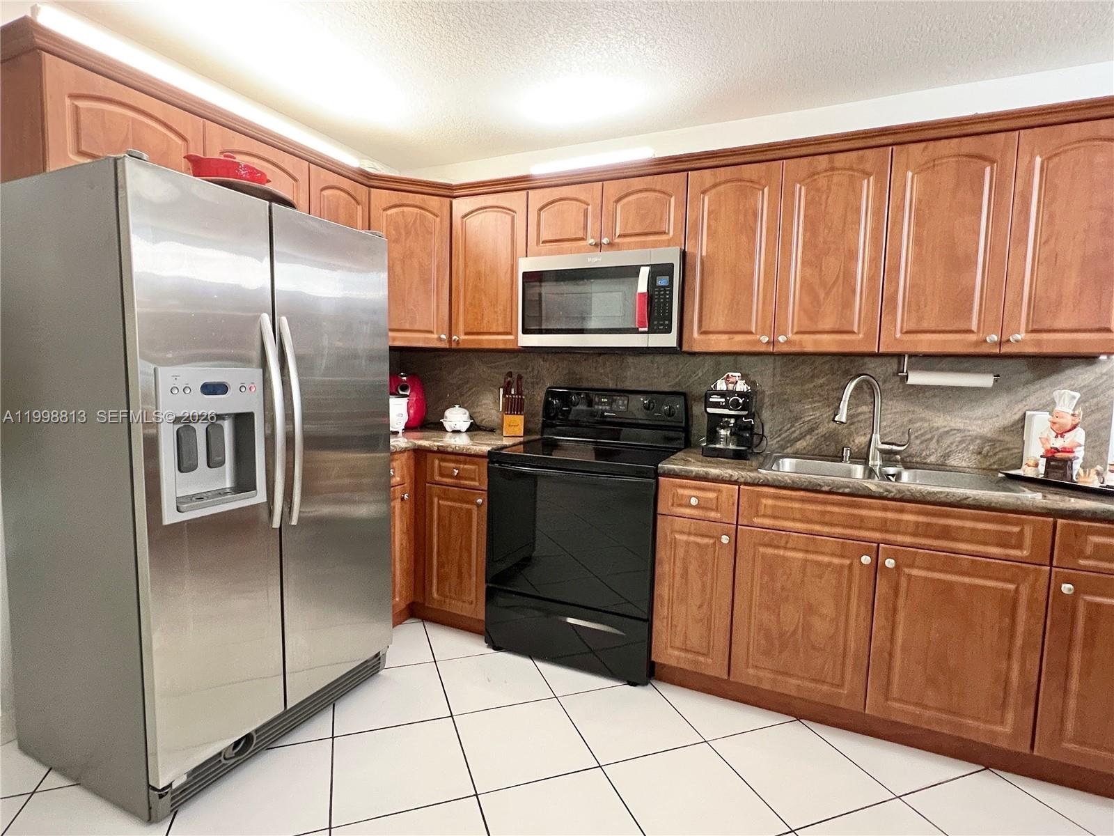 10140 Southwest 26th Terrace Miami, FL 33165 - Photo 38 of 70 a kitchen with stainless steel appliances granite countertop a refrigerator and a sink