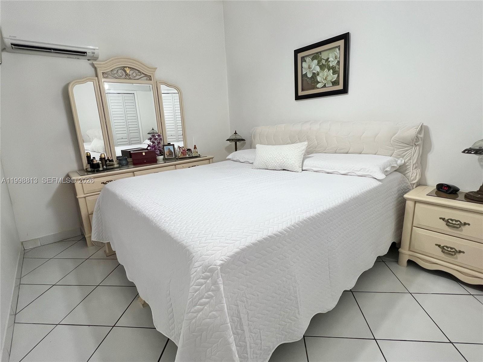 10140 Southwest 26th Terrace Miami, FL 33165 - Photo 42 of 70 a room with a bed a mirror and dresser