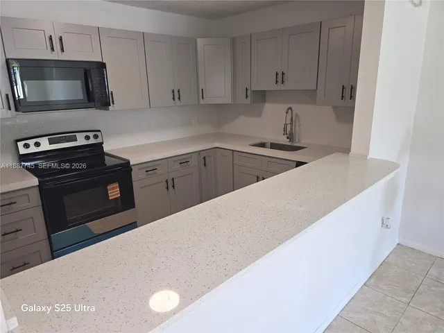 a kitchen with stainless steel appliances a stove a microwave and white cabinets