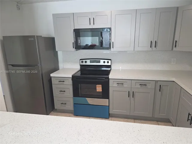 a kitchen with stainless steel appliances white cabinets and a refrigerator