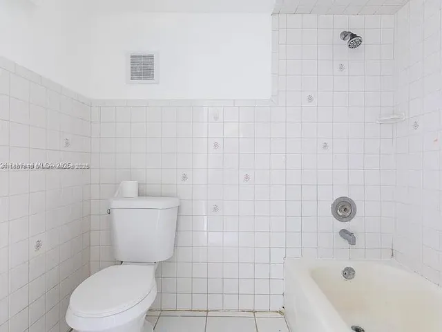 a white toilet sitting next to a bath tub