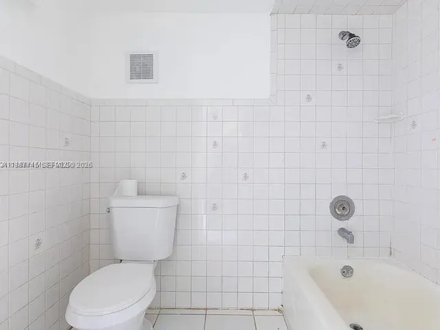 a white toilet sitting next to a bath tub