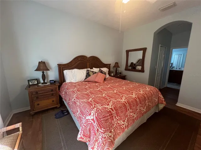 a bedroom with a bed and a mirror on dresser