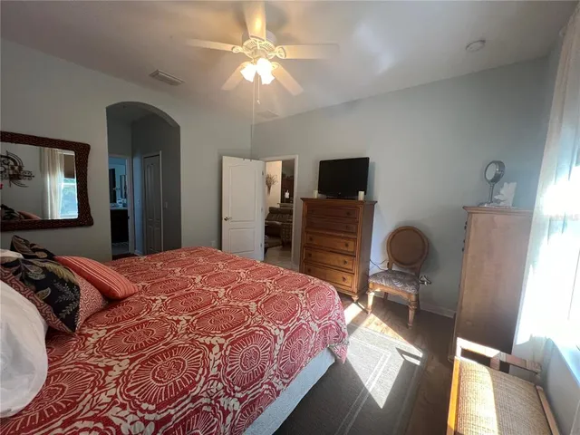a bedroom with a bed dresser and a flat tv screen