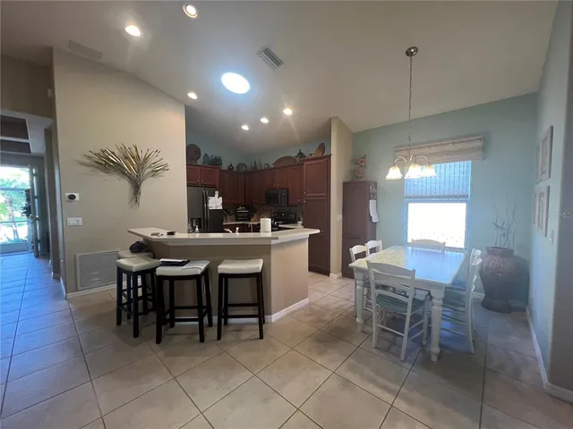 a kitchen with a sink and chairs