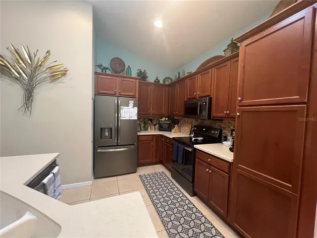 a kitchen with stainless steel appliances granite countertop a refrigerator and a stove top oven