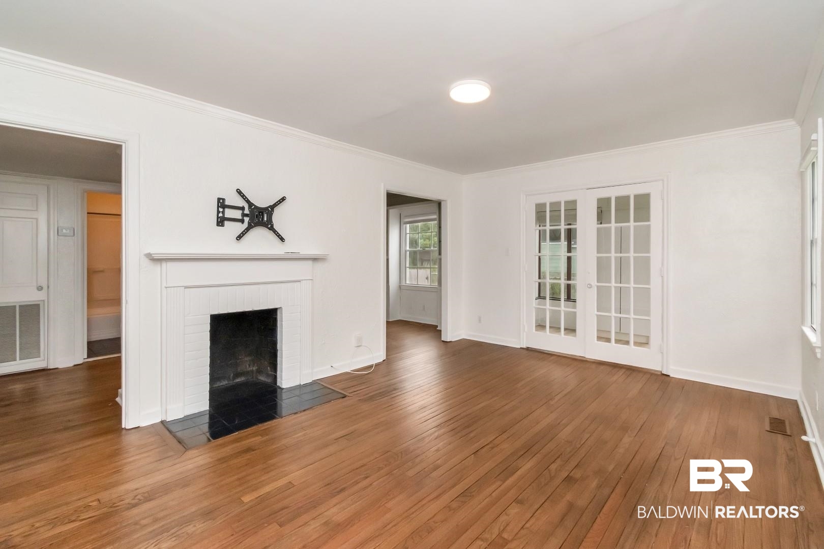 208 Morgan Avenue Mobile, AL 36606 - Photo 7 of 27 Unfurnished living room with ornamental molding, a brick fireplace, and dark hardwood / wood-style flooring