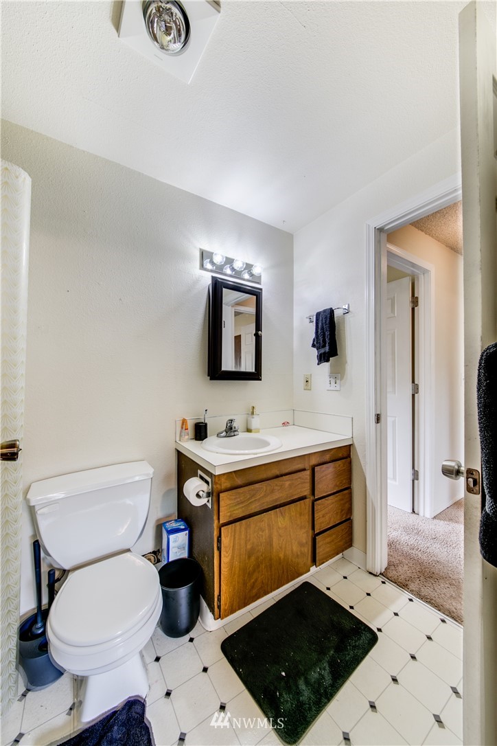 3901 Mason Loop Road, Unit AD Tacoma, WA 98409 - Photo 17 of 20 a bathroom with a sink toilet a mirror and shower