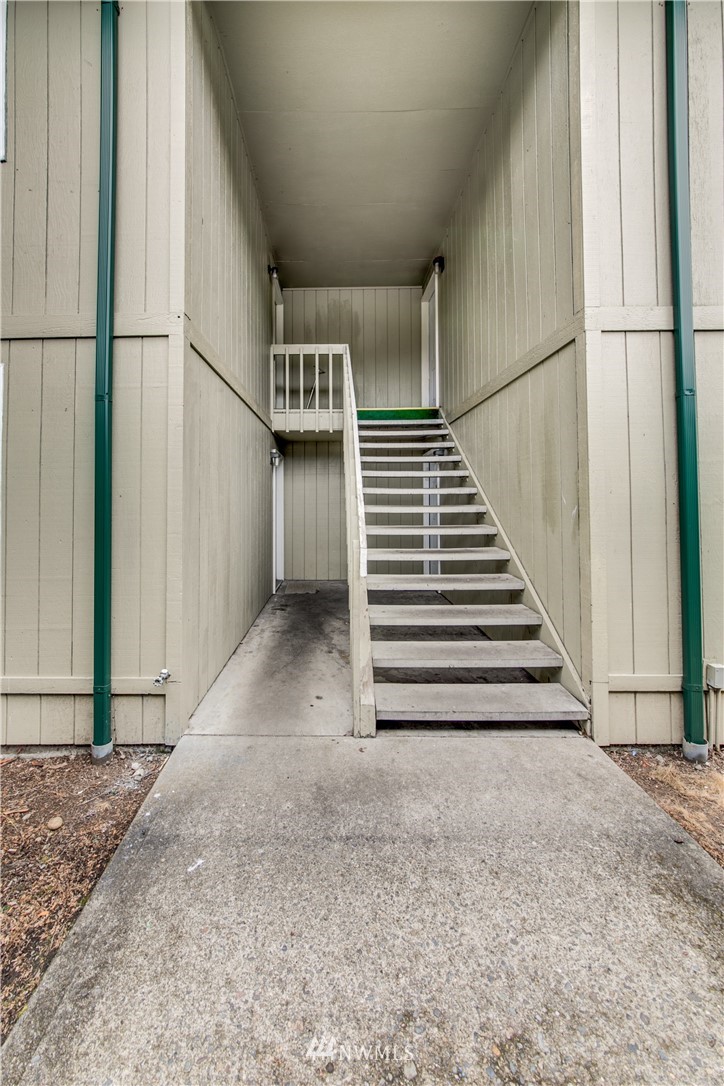 3901 Mason Loop Road, Unit AD Tacoma, WA 98409 - Photo 5 of 20 a view of a hallway with stairs and wooden floor