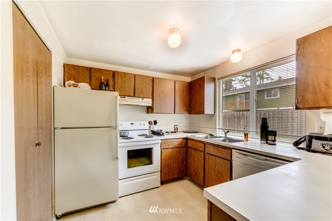 3901 Mason Loop Road, Unit AD Tacoma, WA 98409 - Photo 6 of 20 a kitchen with a sink a refrigerator a stove and cabinets