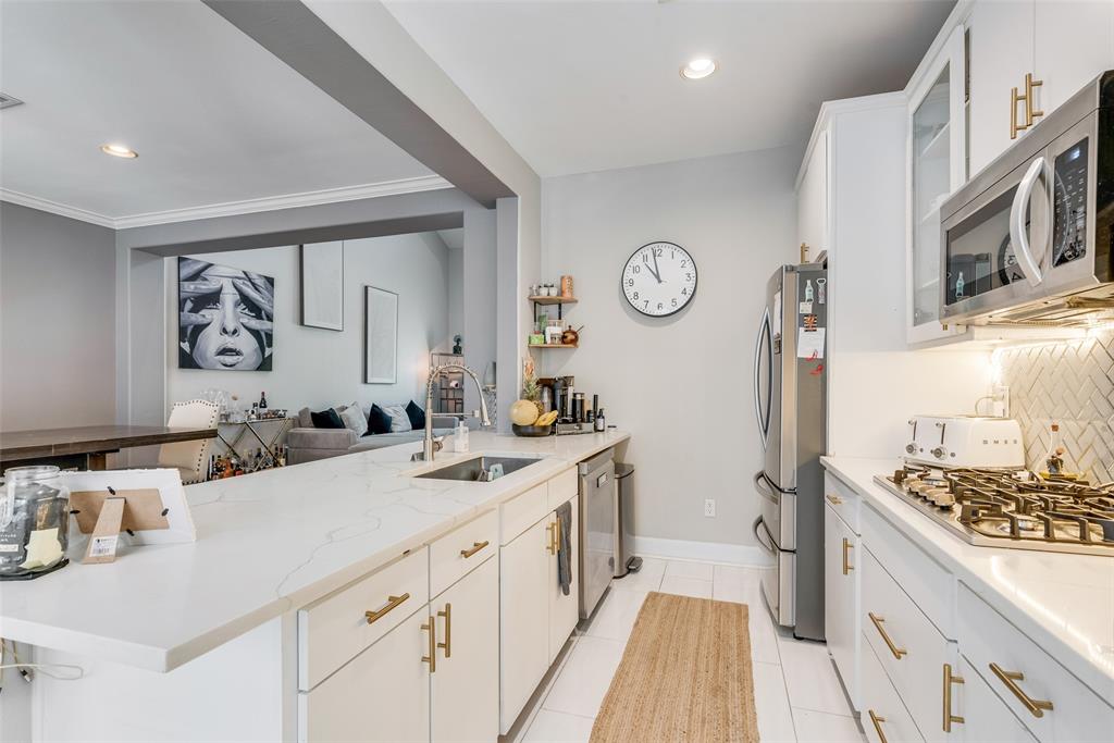 4904 Live Oak Street, Unit 302 Dallas, TX 75206 - Photo 13 of 25 a kitchen with a sink stove and cabinets
