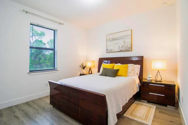 a view of a electric appliances in kitchen and an empty room with wooden floor