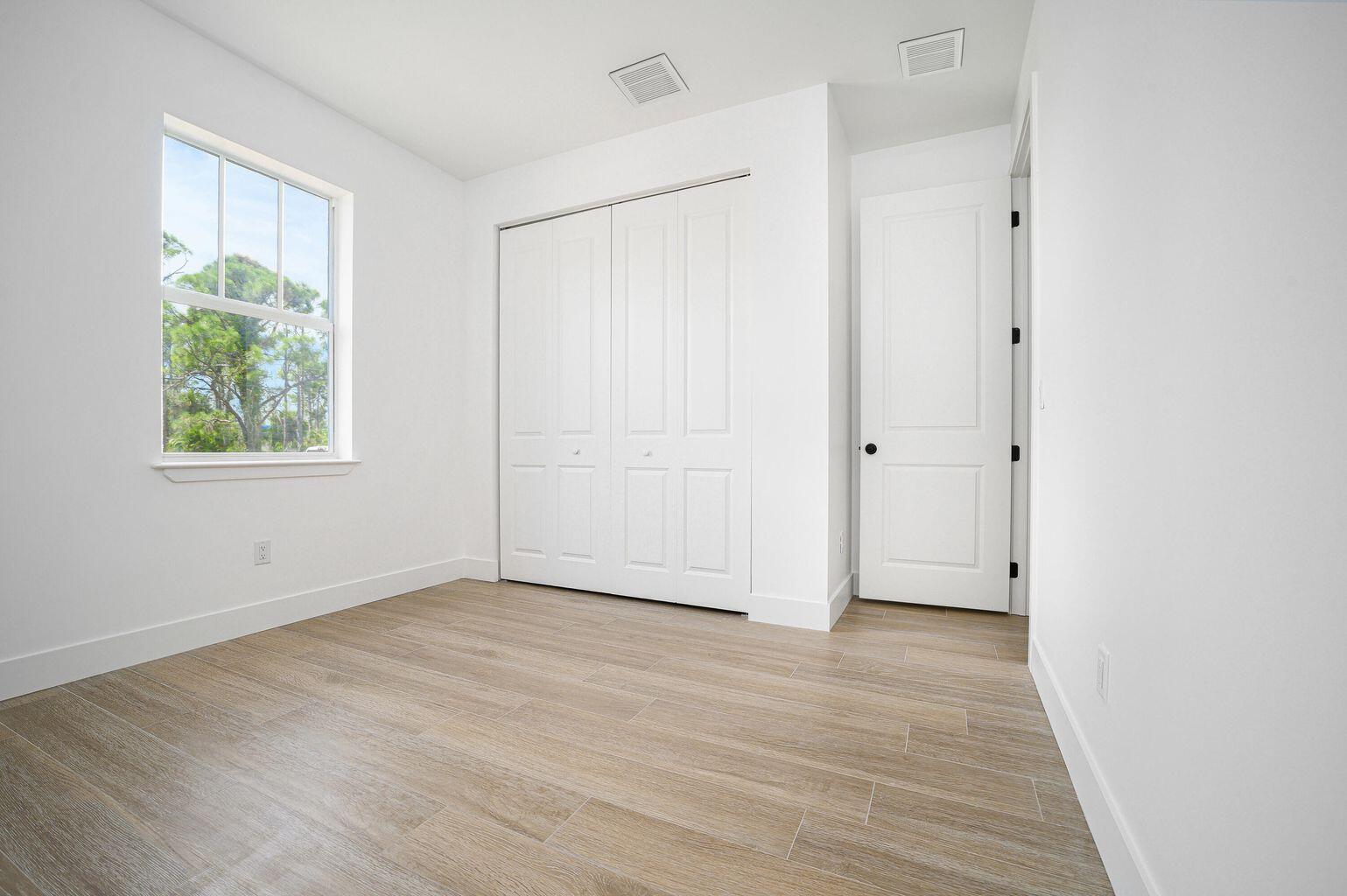 15245 Brainbridge Circle Port Charlotte, FL 33981 - Photo 28 of 52 an empty room with wooden floor and windows