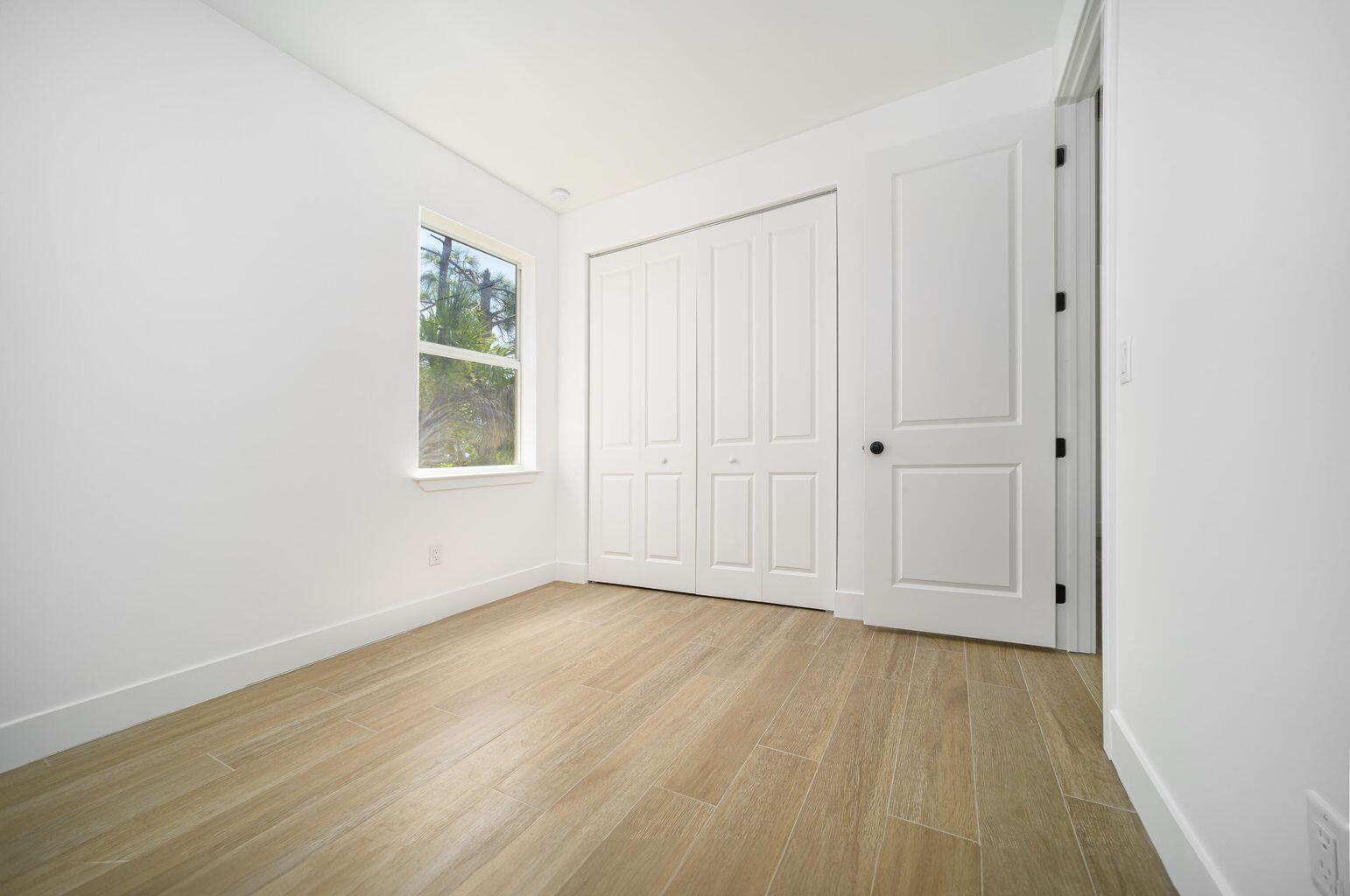15245 Brainbridge Circle Port Charlotte, FL 33981 - Photo 32 of 52 an empty room with wooden floor and windows